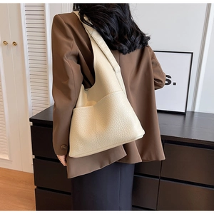 Détail du sac hobo crème en cuir grainé avec une grande poche latérale pratique