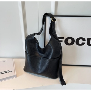 Détail du sac Hobo en cuir grainé noir avec poches et boucle dorée ajustable