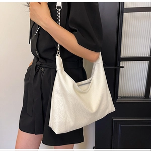 Detailed view of the white pebble leather Hobo bag with silver chain strap on model