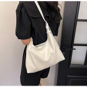 Detail view of large white pebble grain leather tote bag with elegant shoulder straps