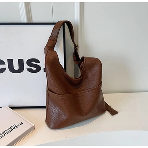 Détail du sac à main marron en cuir grainé avec une poche extérieure pratique