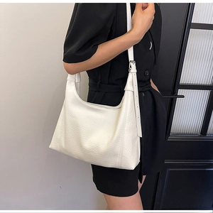 White litchi pattern leather tote bag with silver buckle worn on shoulder
