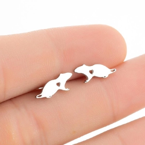 Detailed close-up of silver mouse stud earrings with heart cut-out held by fingers