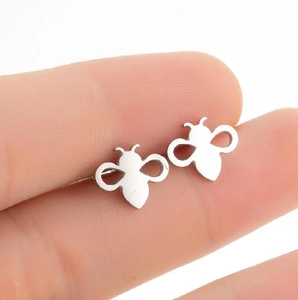 Macro shot of silver honey bee stud earrings with hollow wings held by fingers