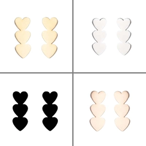 Detail of triple heart drop earrings in gold, silver, black, and rose gold finishes