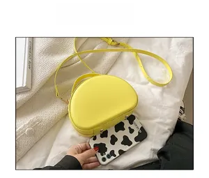 Dettaglio della borsa a conchiglia giallo brillante e confronto dimensioni con cover
