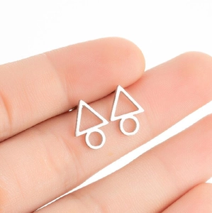 Minimalist silver geometric stud earrings with triangle and circle design on finger