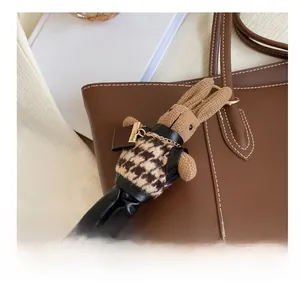 Charm lapin tressé marron avec gilet pied-de-poule suspendu à un grand cabas cuir