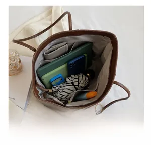 Vue de dessus d'un cabas marron montrant sa grande capacité pour tablettes et accessoires