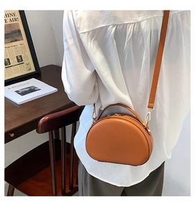 Vista posteriore della borsa a conchiglia vintage in pelle marrone indossata da una modella