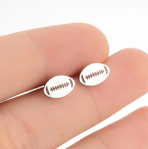 Détail macro de boucles d'oreilles mini football américain en acier avec gravure laser