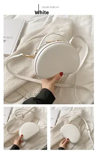 Dettagli di una borsa a tracolla bianca a conchiglia con finiture dorate e pelle liscia