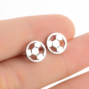 Gros plan de boucles d'oreilles ballon de football en acier argenté sur un doigt