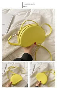 Dettaglio della borsa a conchiglia gialla in pelle PU con zip in metallo e tracolla