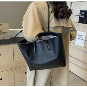 Detail of black leather tote bag showing double straps and silver silk interior lining