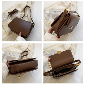 Detail view of brown leather crossbody bag with gold hardware and internal compartments