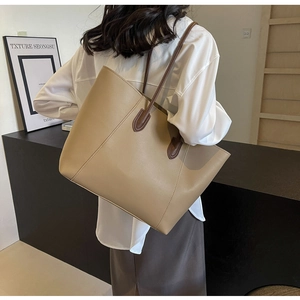 Close-up of a khaki large-capacity tote bag featuring sleek dark brown shoulder straps