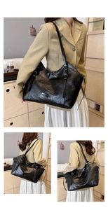 Dettaglio della borsa tote in pelle lucida nera con fibbie argentate ed etichetta moda