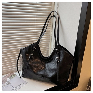 Dettaglio borsa shopper nera con trama stropicciata lucida e fibbia argento