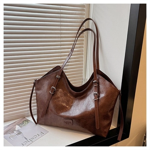 Dettaglio della pelle oliata vintage e del logo FASHION BAGS sulla grande borsa shopper