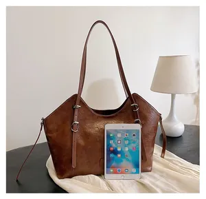 Borsa tote marrone effetto cerato mostrata con un tablet per confronto dimensioni