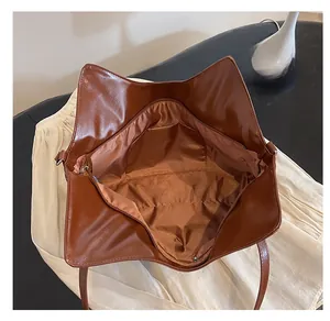 Vista dettagliata dell'interno di una borsa tote marrone con tasca zip e fodera liscia