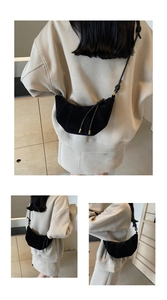 Detail view of black crescent bag with matte finish and rope strap worn by a model