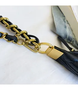 Dettaglio della catena dorata con pelle intrecciata e robusti ganci a scatto