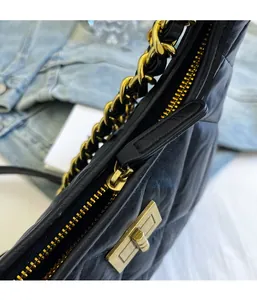 Dettaglio della borsa a secchiello nera trapuntata con zip dorata e chiusura a girello