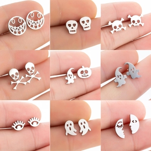 Detailed close-up of 9 pairs of stainless steel Halloween earrings on fingertips for scale