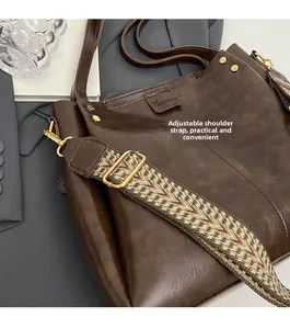 Detail of vintage dark brown PU leather tote with a colorful bohemian woven strap