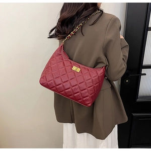 Dettaglio borsa hobo rossa trapuntata con catena dorata e chiusura a girello in metallo