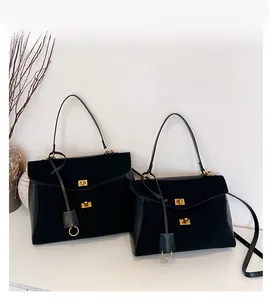 Detailed comparison of large and small black matte leather tote bags with gold hardware