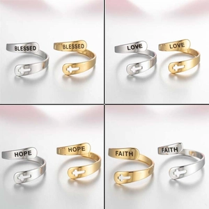 Detail of adjustable cross rings with Faith and Blessed engravings in gold and silver