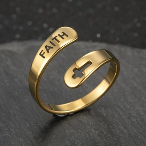 Macro shot of gold stainless steel ring featuring FAITH engraving and hollow cross detail