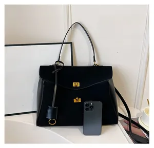 Detail of black matte tote bag showing interior capacity and golden turn-lock fasteners