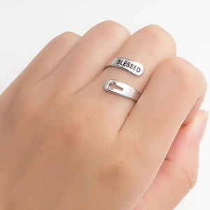 Close-up of silver ring featuring engraved Blessed text and hollow cross detail