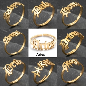 Detailed grid of gold gothic rings with Angel and Aries letter designs on stone surface