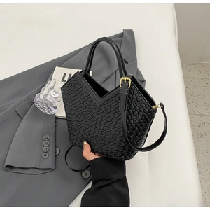 Detail der schwarzen Handtasche mit Webstruktur, V-Ausschnitt und goldener Schnalle