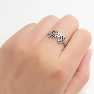 Close-up of hip-hop silver ring with cutout GROOVY letter design on model's finger