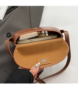 Vue intérieure du sac besace vintage marron avec smartphone et cosmétiques