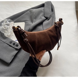 Detail of dark brown matte croissant shoulder bag with stylish knot design and slender strap