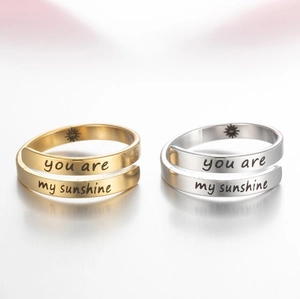 Macro detail of 'You are my sunshine' engraving on gold and silver stainless steel rings