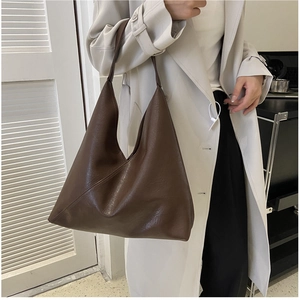 Detail view of large brown soft leather tote bag with diagonal stitching and hobo silhouette