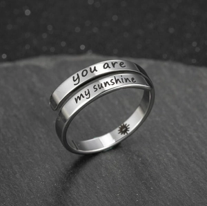 Detail of silver stainless steel ring with you are my sunshine engraving and sun icon