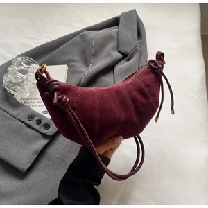 Detail of burgundy suede croissant bag with vertical stitching and knotted drawstring