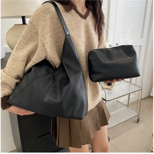 Detail of black faux leather tote bag and pouch set showing soft texture and large capacity