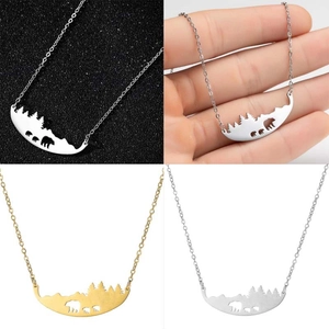 Detailed views of mountain and bear silhouette pendants in gold and silver finishes
