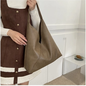 Detail of vintage soft leather tote bag with unique V-cut opening and sleek shoulder strap
