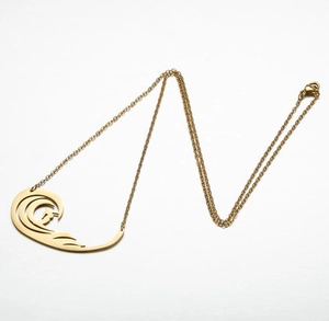 Close-up of a gold wave pendant necklace with smooth hollow lines on a white background